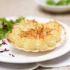 coquille aux fruits de mer dans une assiette blanche avec de la salade