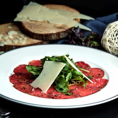 carpaccio slices topped with arugula and parmesan slice